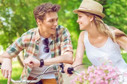 Un homme et une femme à vélo dans un parc.