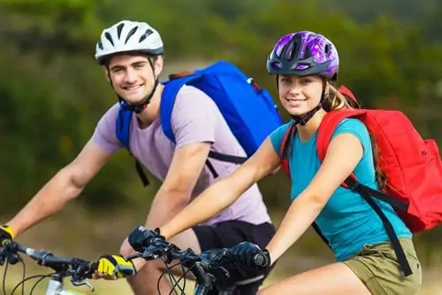 Un homme et une femme font du vélo dans un champ.