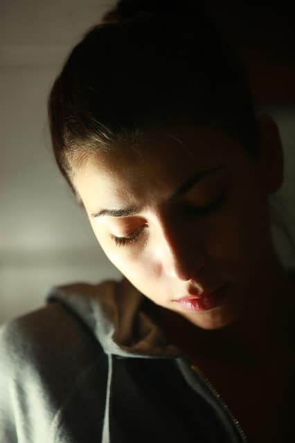 Une femme regarde son téléphone dans le noir.